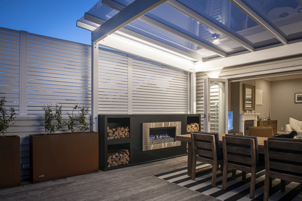Outdoor area with fireplace, rain cover, and privacy fencing